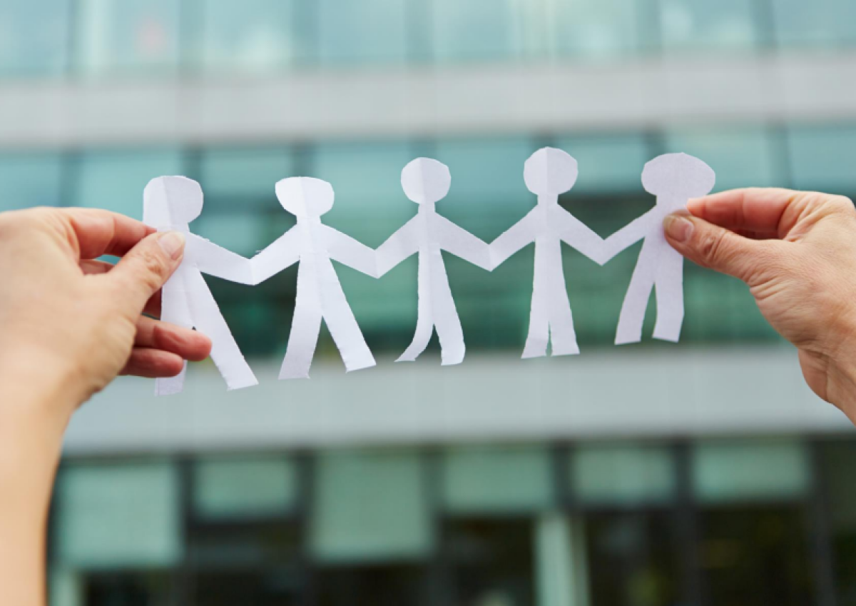 Hender som holder opp en remse med papirdukker.