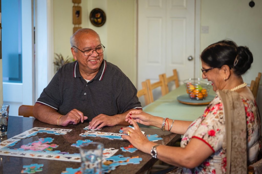 Eldre mann og kvinne legger puslespill
