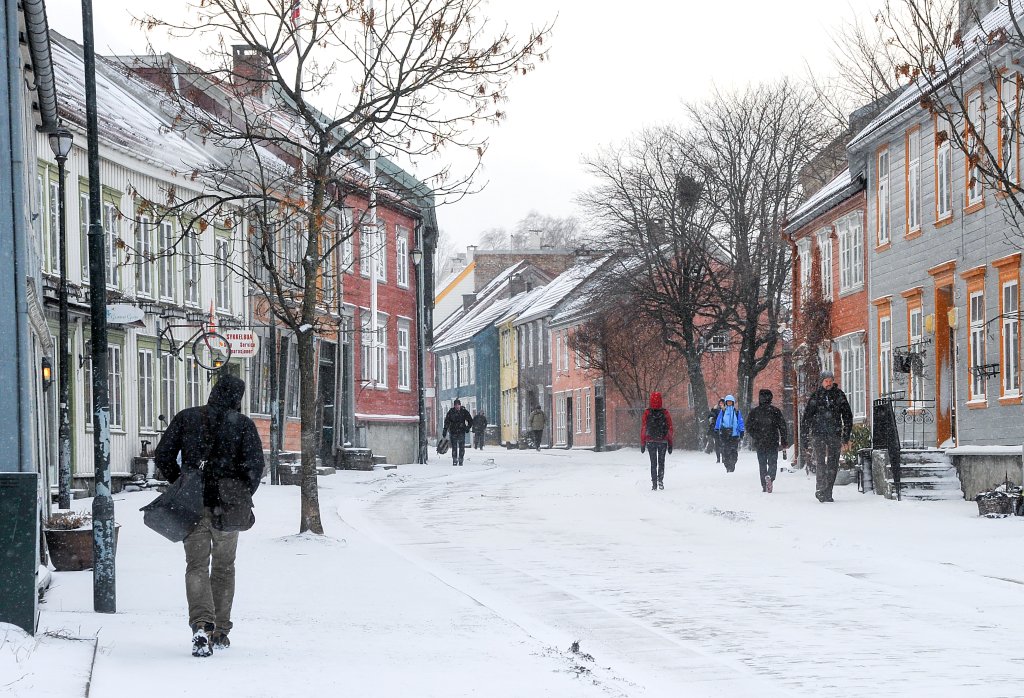 Fortgjenere på fortauet i en snødekt gate