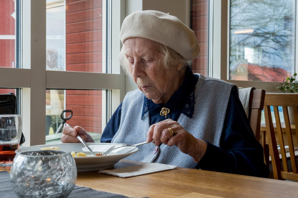 Eldre kvinner som spiser mat. 