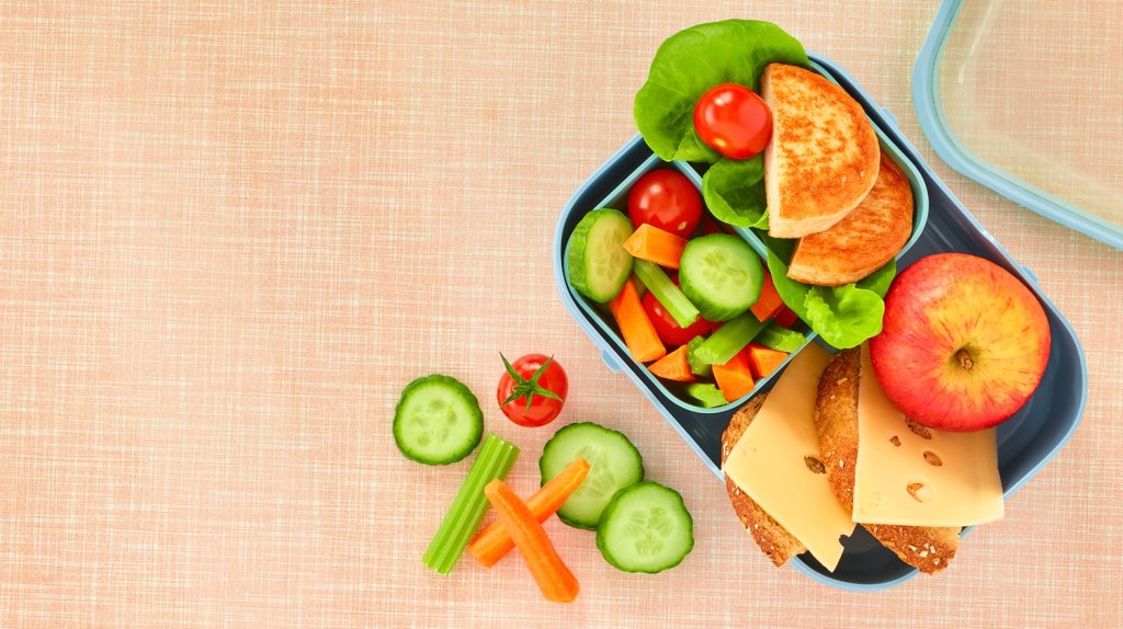 Grønnsaker og brødskiver i en matboks