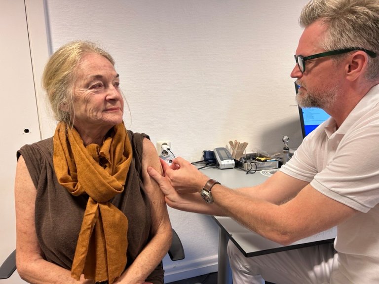 Eldre dame på 75 år får influensavaksine i armen av fastlege