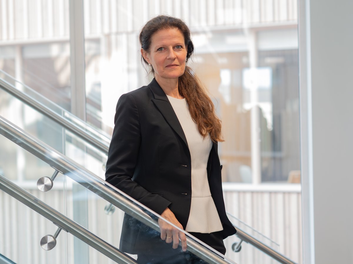 kvinne med langt hår og dress i trapp