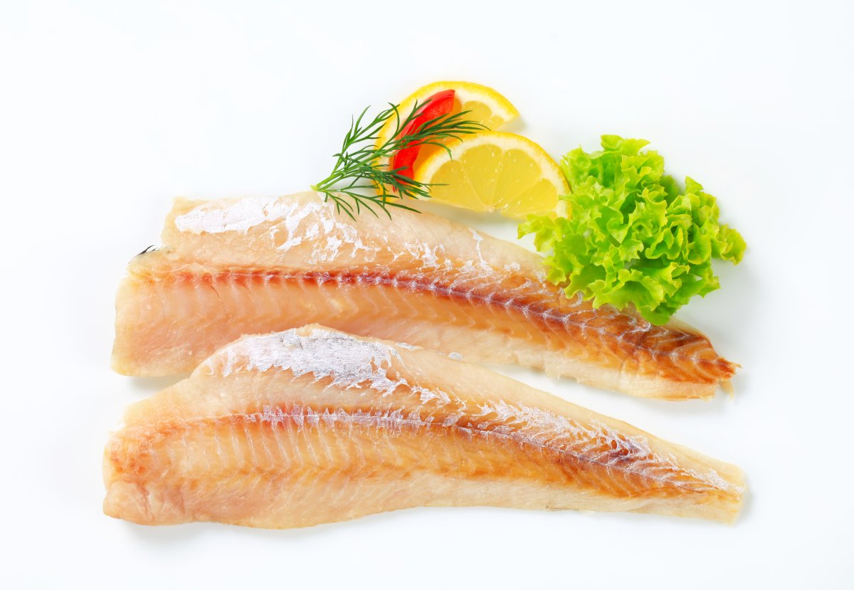 To stykker hvit fisk med sitron og salat.