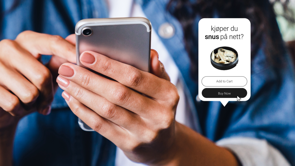 Bilde av en hånd som holder en gammel mobiltelefon. 