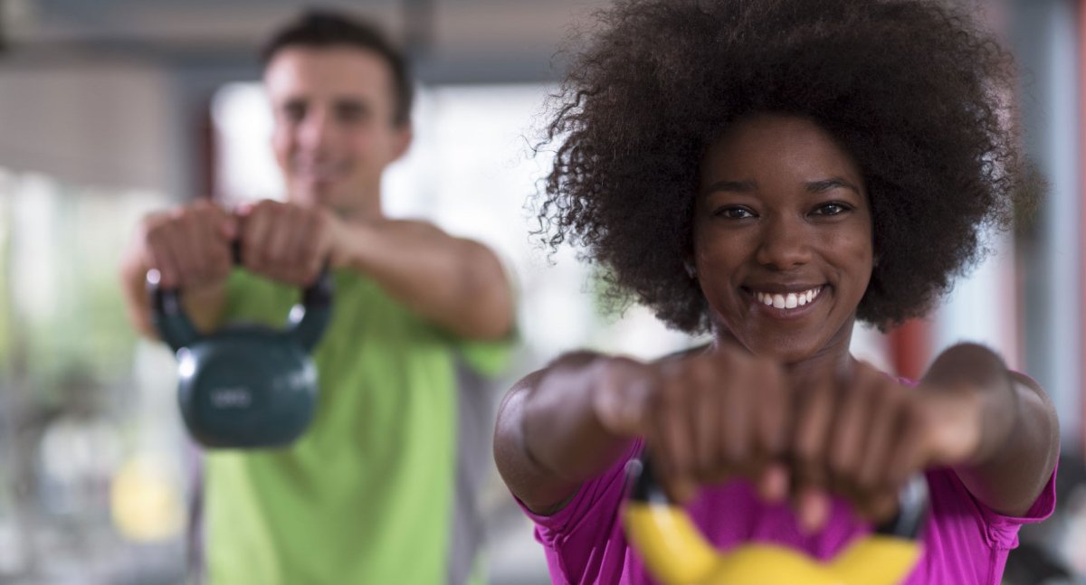 To personer som løfter vekter foran seg.