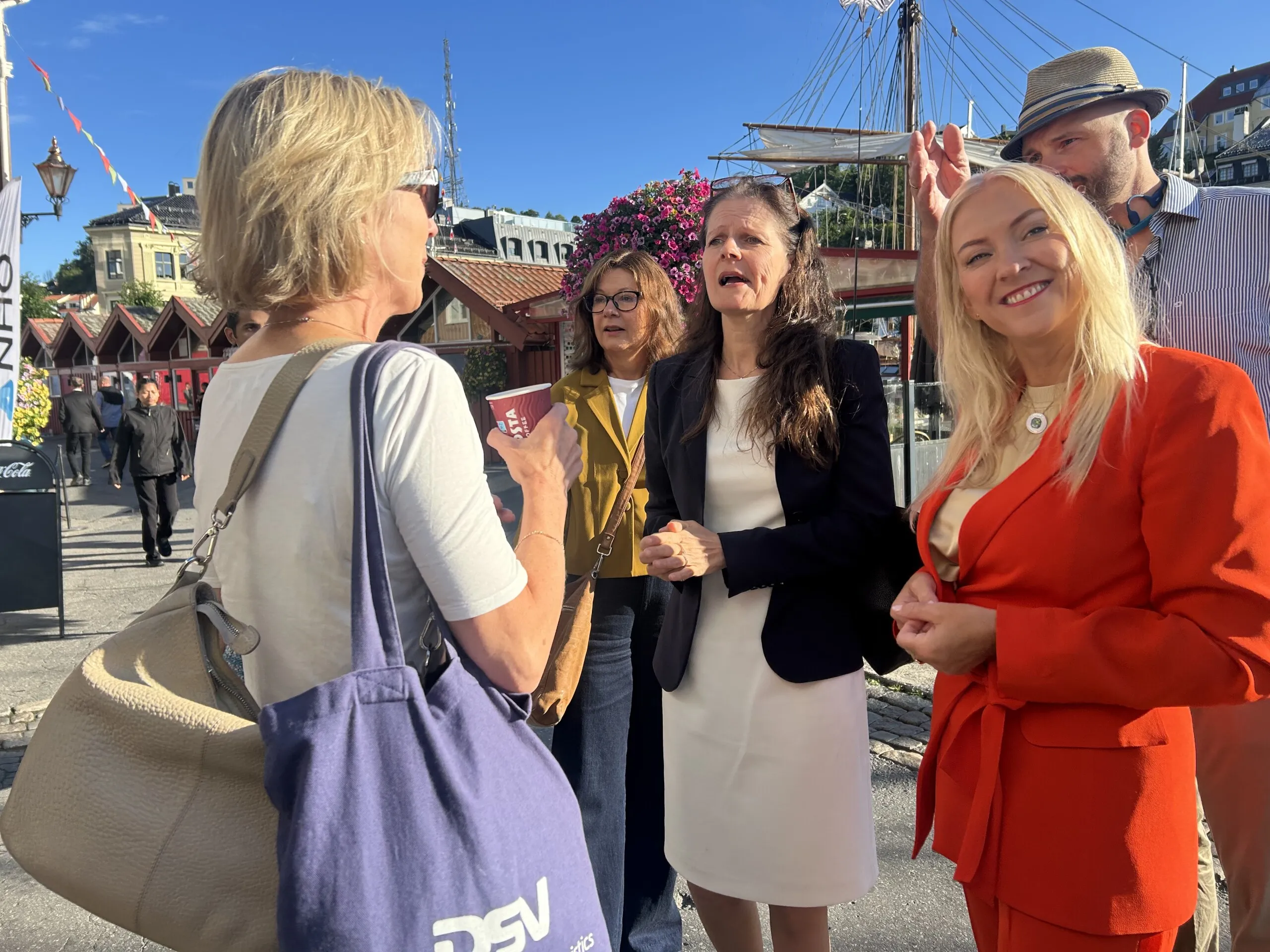 Bilde av fire kvinner og en mann med hatt i debatt