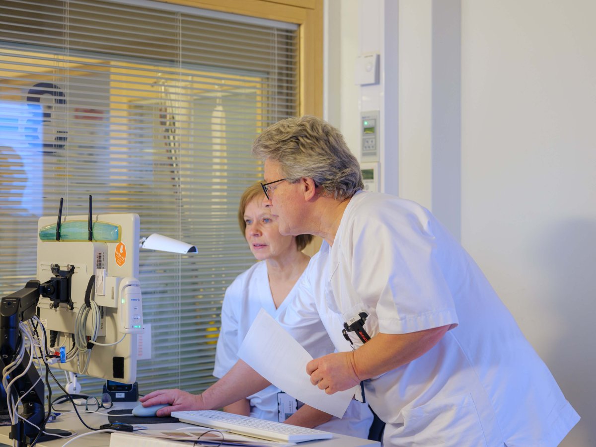 Bilde av helsepersonell som ser på en skjerm