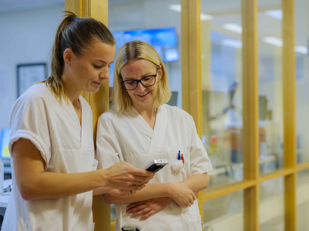To sykepleiere ser på en mobil