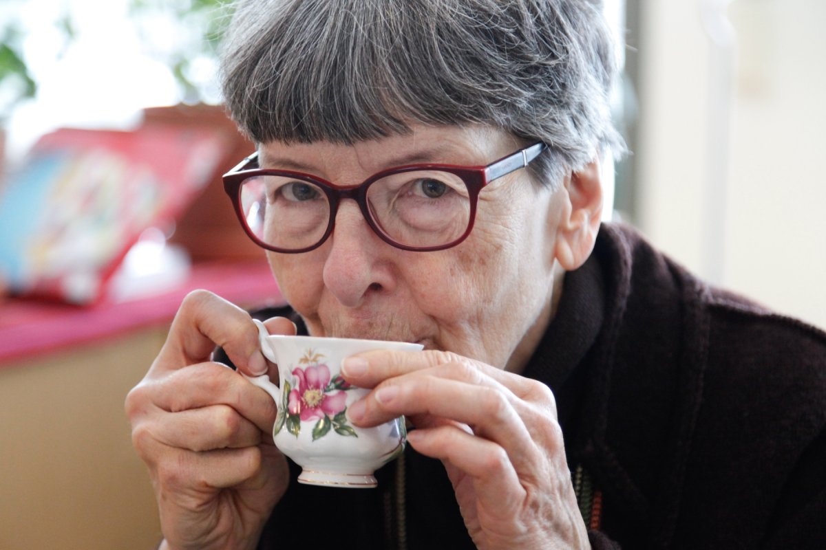 Eldre kvinne drikker kaffe