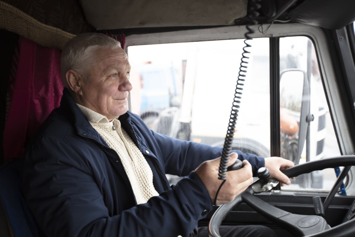 En eldre mann sitter bak rattet i en lastebil