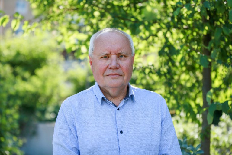 Avdelingsdirektør Steinar Mathisen står utendørs foran grønne trær