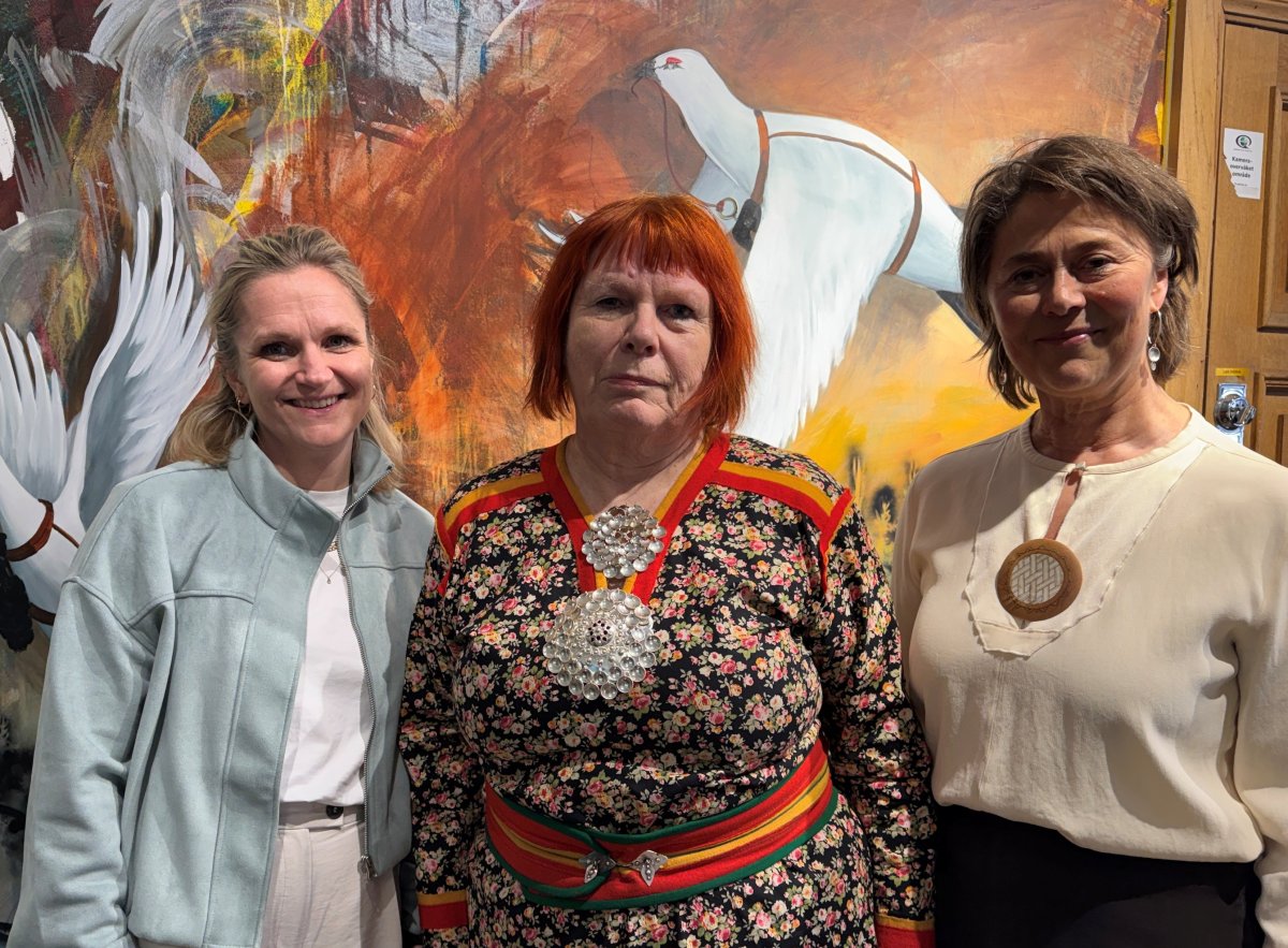 Tre damer foran en vegg