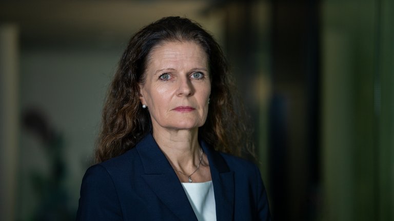 portrettbilde av kvinne med langt mørt hår og dressjakke