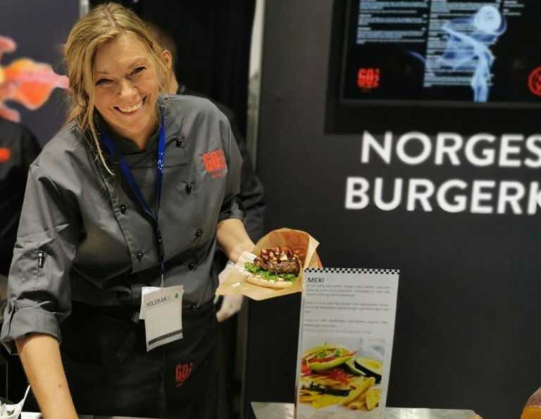 Bilde av Anne-Lise Sørensen fra Patricias gatekjøkken som holder en hamburger. Foto: Karine H. Henriksen, Convenience.